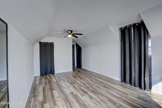 bonus room featuring lofted ceiling, a ceiling fan, baseboards, and wood finished floors