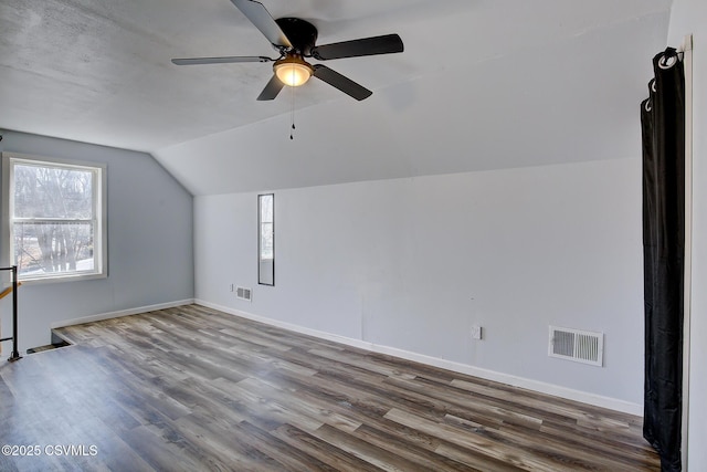 additional living space featuring lofted ceiling, visible vents, baseboards, and wood finished floors