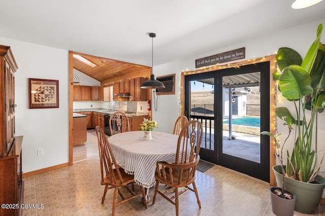 dining space with lofted ceiling and baseboards