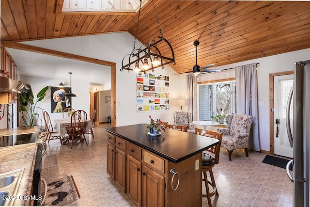 kitchen featuring dark countertops, a kitchen island, pendant lighting, and brown cabinetry