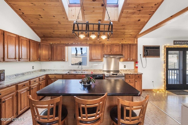 kitchen with appliances with stainless steel finishes, lofted ceiling with skylight, wood ceiling, a sink, and a wall mounted air conditioner