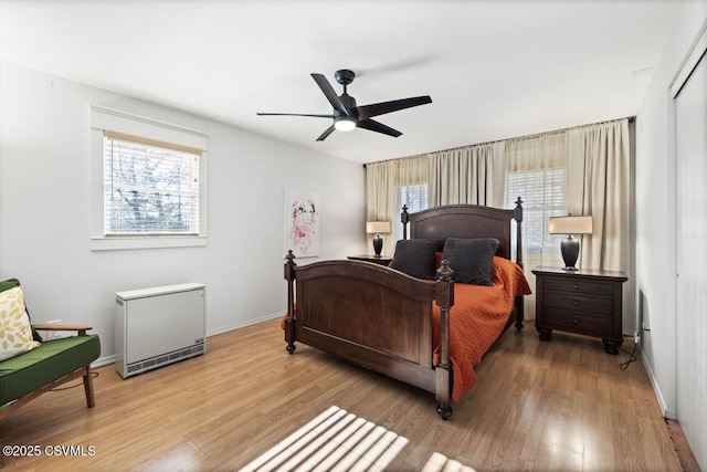 bedroom with a ceiling fan, light wood-type flooring, and baseboards