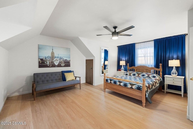 bedroom featuring a ceiling fan, vaulted ceiling, baseboards, and wood finished floors