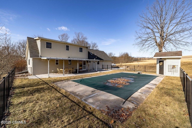 view of pool with a fenced in pool, a fenced backyard, an outdoor structure, a patio area, and a shed