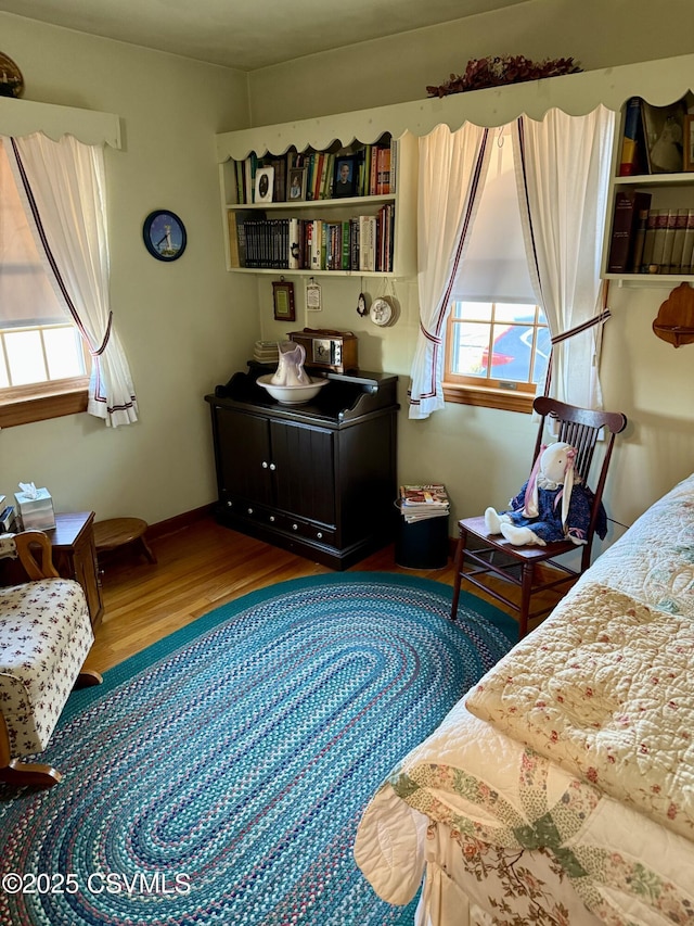 bedroom featuring baseboards and wood finished floors