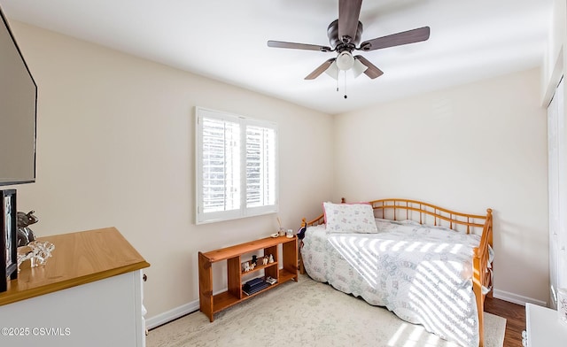 bedroom featuring ceiling fan, baseboards, and wood finished floors