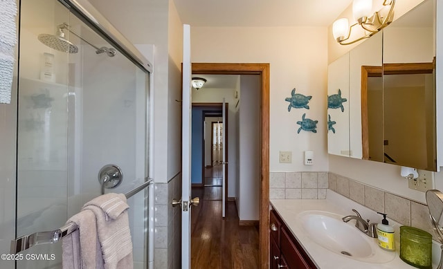 full bathroom with a stall shower, wood finished floors, and vanity