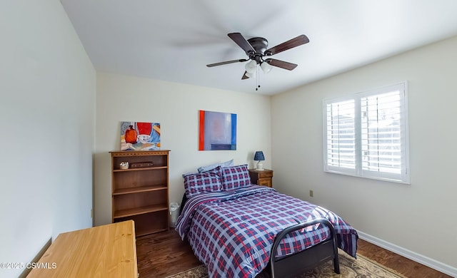 bedroom with dark wood-style floors, ceiling fan, and baseboards