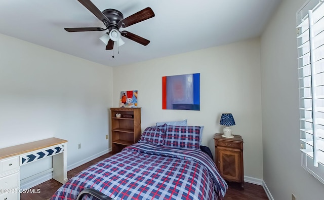 bedroom featuring multiple windows, baseboards, and wood finished floors