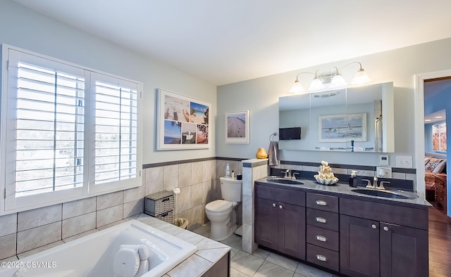 bathroom featuring double vanity, a garden tub, tile walls, and a sink