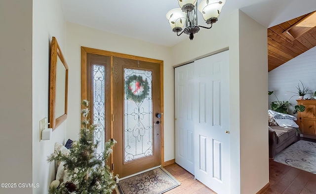 entrance foyer featuring a chandelier, wood finished floors, and lofted ceiling