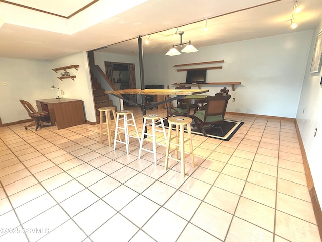 dining area with tile patterned flooring, stairs, baseboards, and track lighting