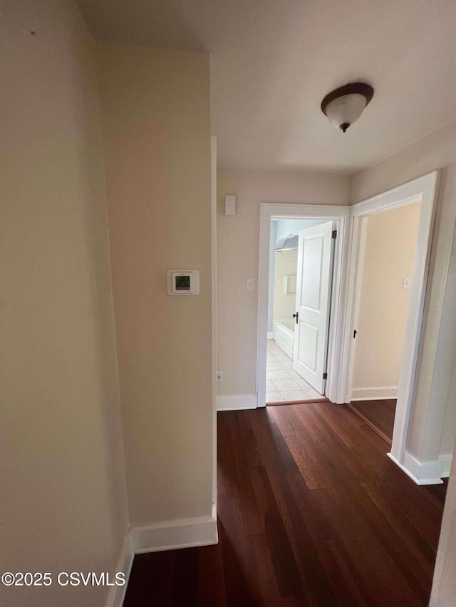 hall featuring baseboards and wood finished floors