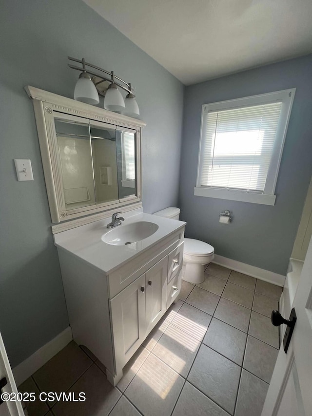 bathroom featuring baseboards, vanity, toilet, and tile patterned floors