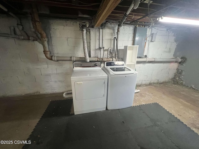 unfinished basement featuring electric panel and washer and clothes dryer