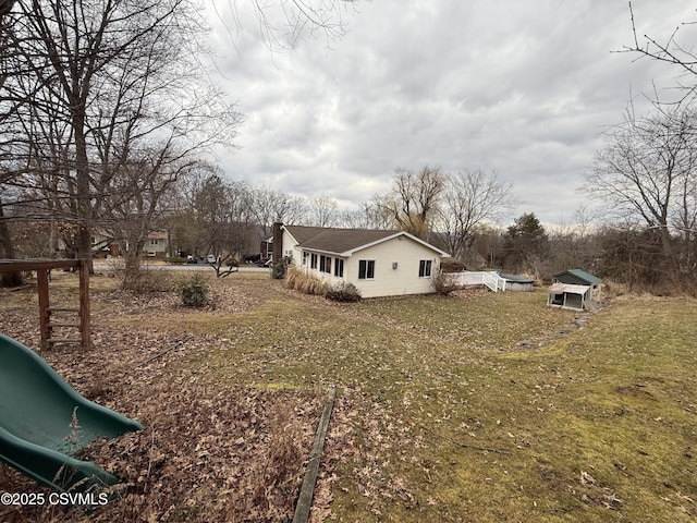 view of side of home featuring a yard and a playground