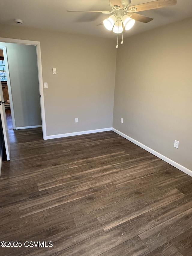 unfurnished room with ceiling fan, dark wood-type flooring, and baseboards