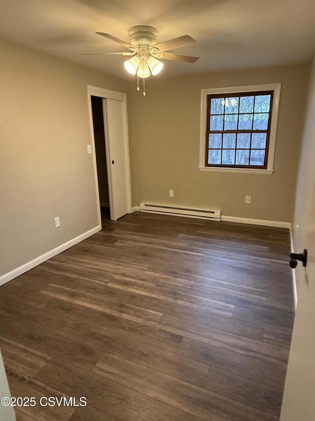 spare room featuring dark wood-style floors, a baseboard radiator, ceiling fan, and baseboards