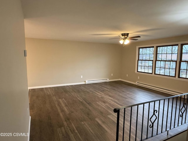 empty room featuring a baseboard heating unit, dark wood-style floors, a ceiling fan, and baseboards