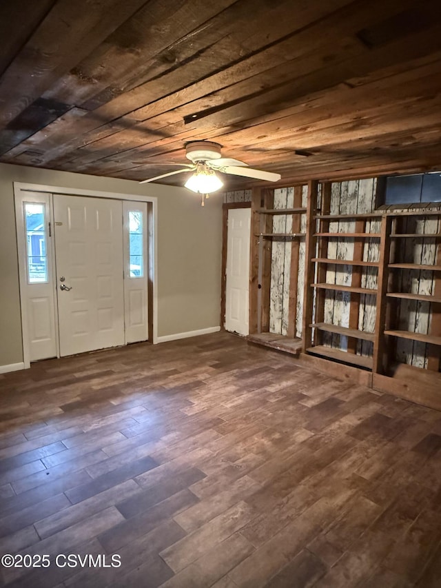 entrance foyer featuring dark wood-type flooring, wooden ceiling, a ceiling fan, and baseboards