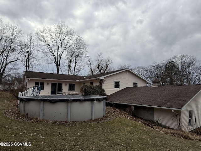 rear view of house featuring a covered pool