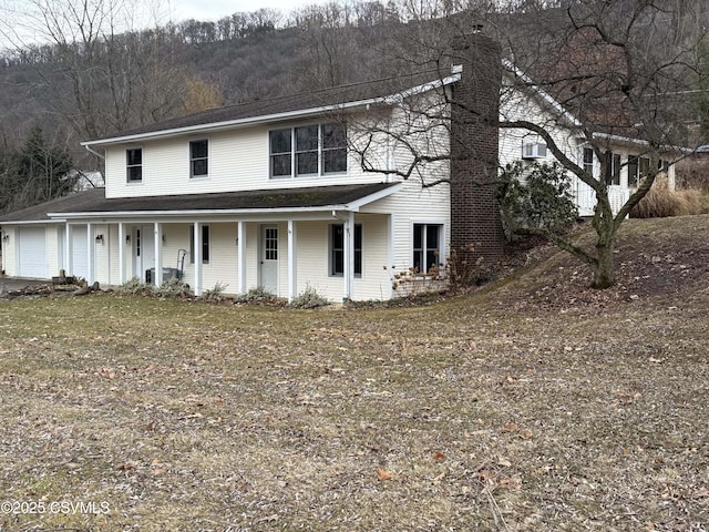 view of front facade with a porch, a garage, and central AC unit