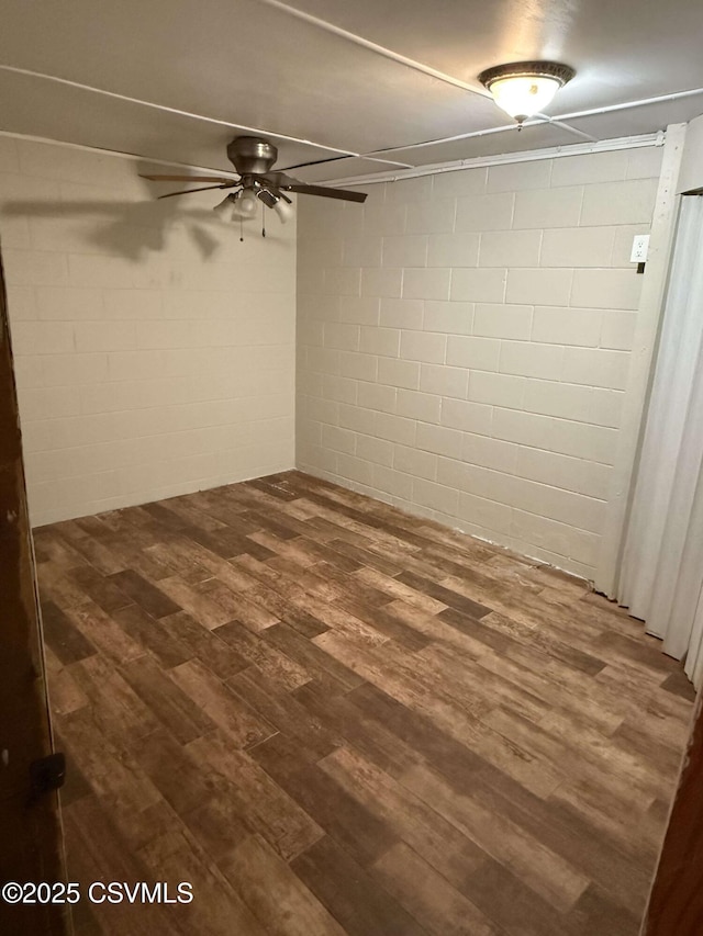 finished basement featuring ceiling fan and dark wood-style flooring