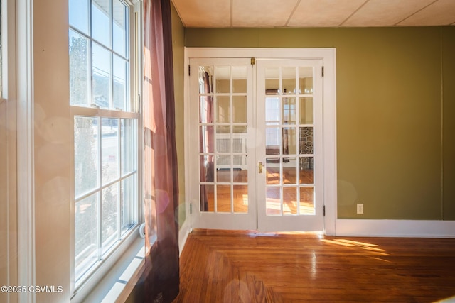 entryway with french doors, a wealth of natural light, and baseboards