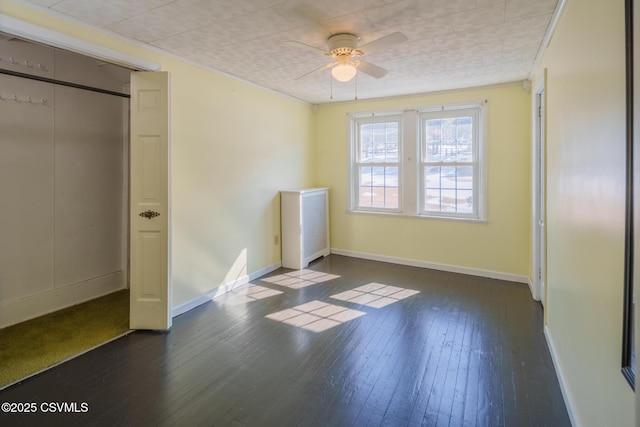 unfurnished bedroom with dark wood finished floors, baseboards, and ceiling fan