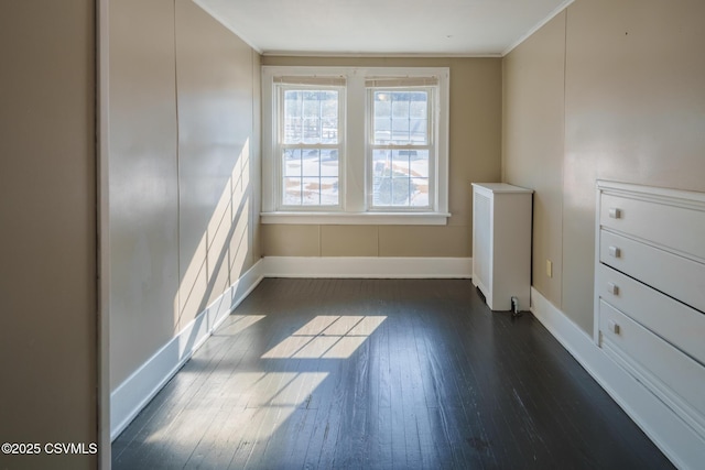 unfurnished room featuring ornamental molding, dark wood-style flooring, and baseboards