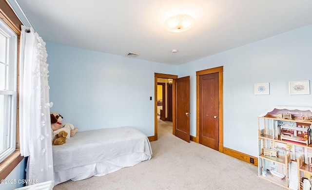 carpeted bedroom featuring visible vents and baseboards