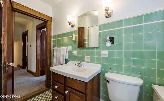 bathroom with toilet, vanity, tile walls, and radiator