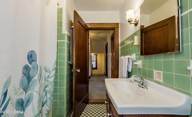 full bath with curtained shower, tile walls, and vanity