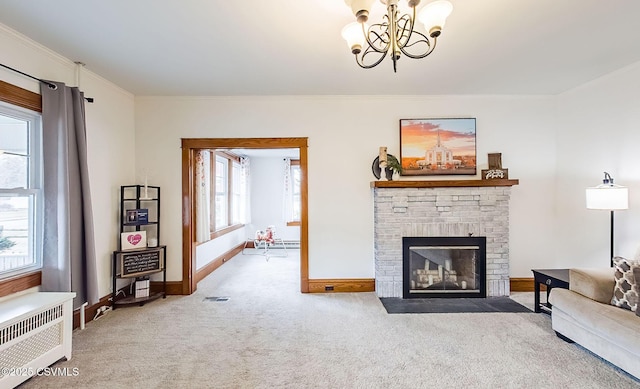 living room featuring carpet, crown molding, a fireplace, a chandelier, and baseboards