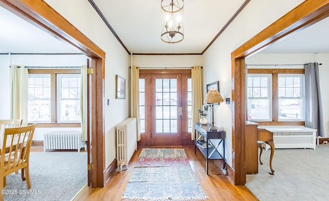 foyer entrance featuring radiator, a wealth of natural light, and a notable chandelier