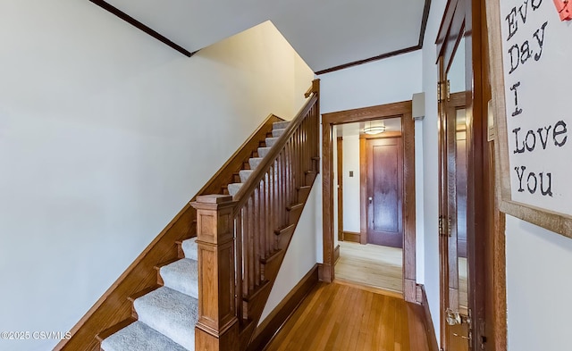 stairs featuring wood finished floors and baseboards