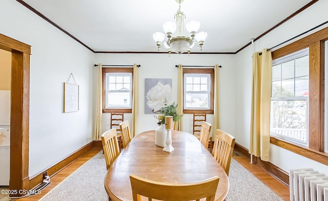 dining area featuring radiator, plenty of natural light, a chandelier, and ornamental molding