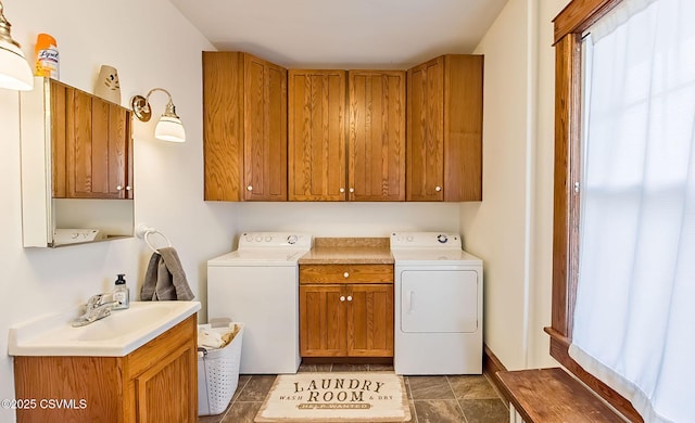 clothes washing area featuring separate washer and dryer, a sink, and cabinet space