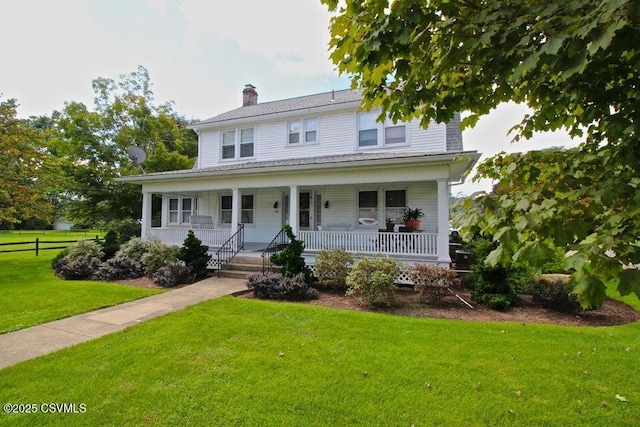 view of front of home featuring covered porch, a chimney, and a front lawn