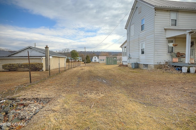 view of yard with fence and central AC unit