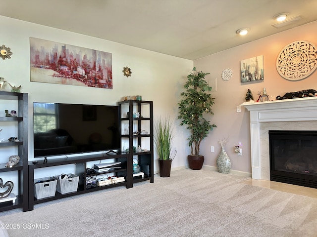 carpeted living room featuring a fireplace and baseboards