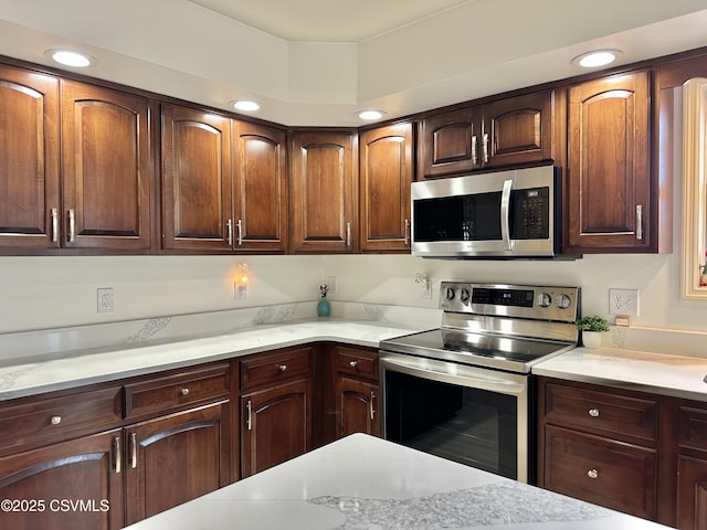 kitchen featuring light stone countertops, appliances with stainless steel finishes, and recessed lighting