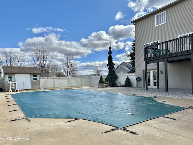 view of pool with a fenced in pool, an outbuilding, french doors, a patio, and a fenced backyard