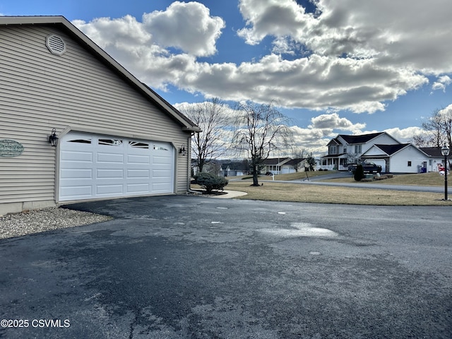 garage with driveway and a residential view