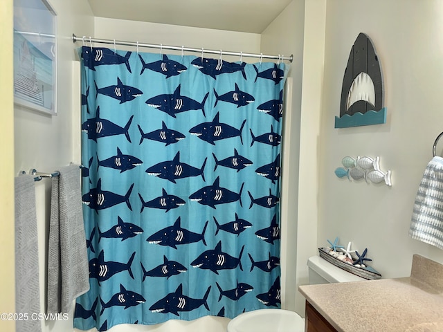 bathroom with toilet, curtained shower, and vanity