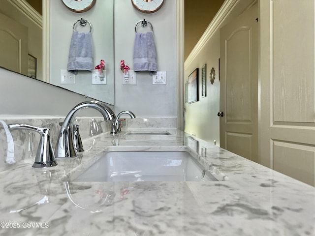 bathroom with crown molding and a sink