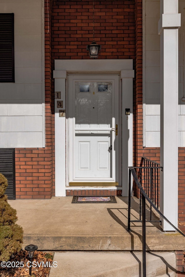 doorway to property with brick siding