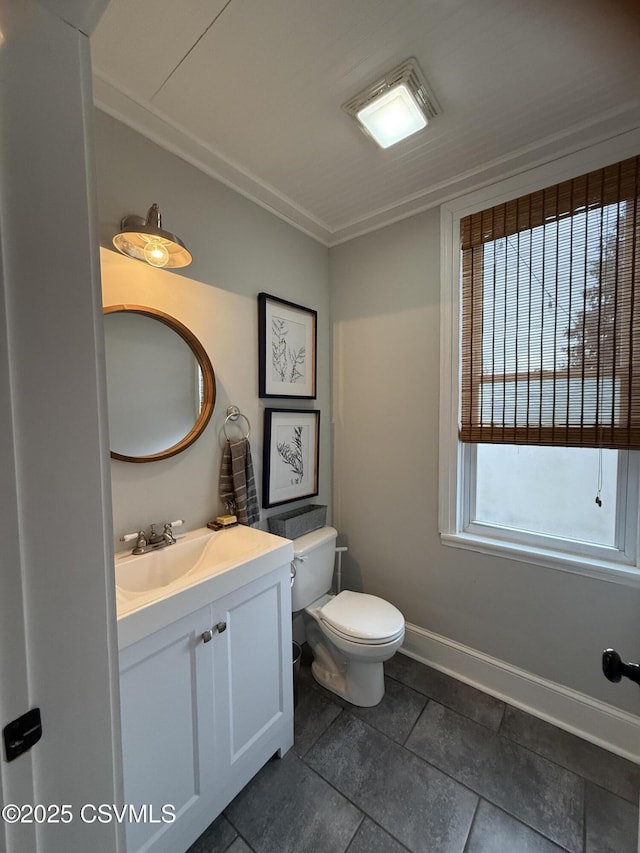 bathroom with vanity, toilet, and baseboards