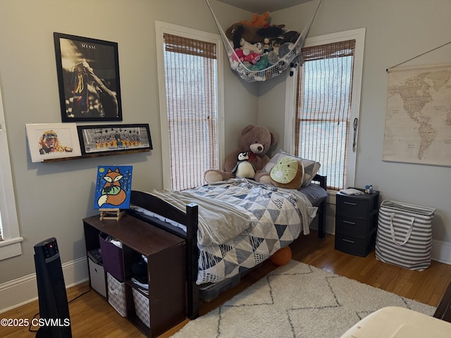 bedroom with baseboards and wood finished floors