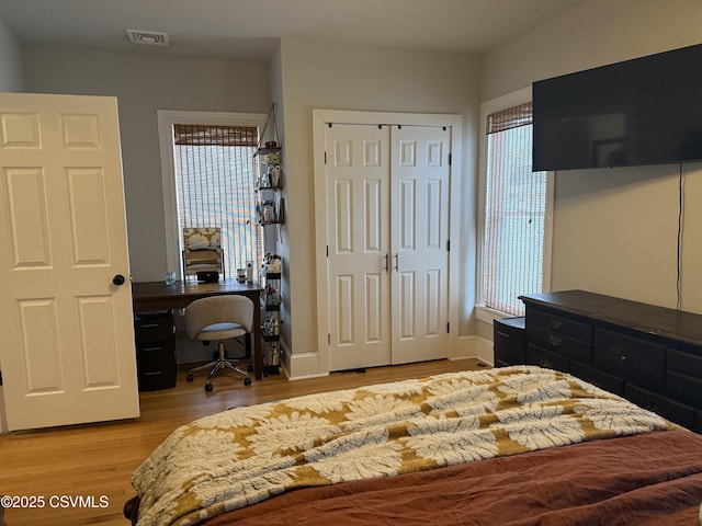 bedroom with light wood-type flooring, multiple windows, and visible vents